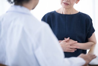 Elder female patient showing stomachache to female physician